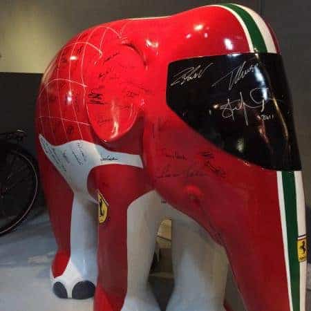 Ferrari Elefant 1 Rzeźba czerwonego słonia z motywem i logotypem Ferrari na wystawie, ozdobiona podpisami.