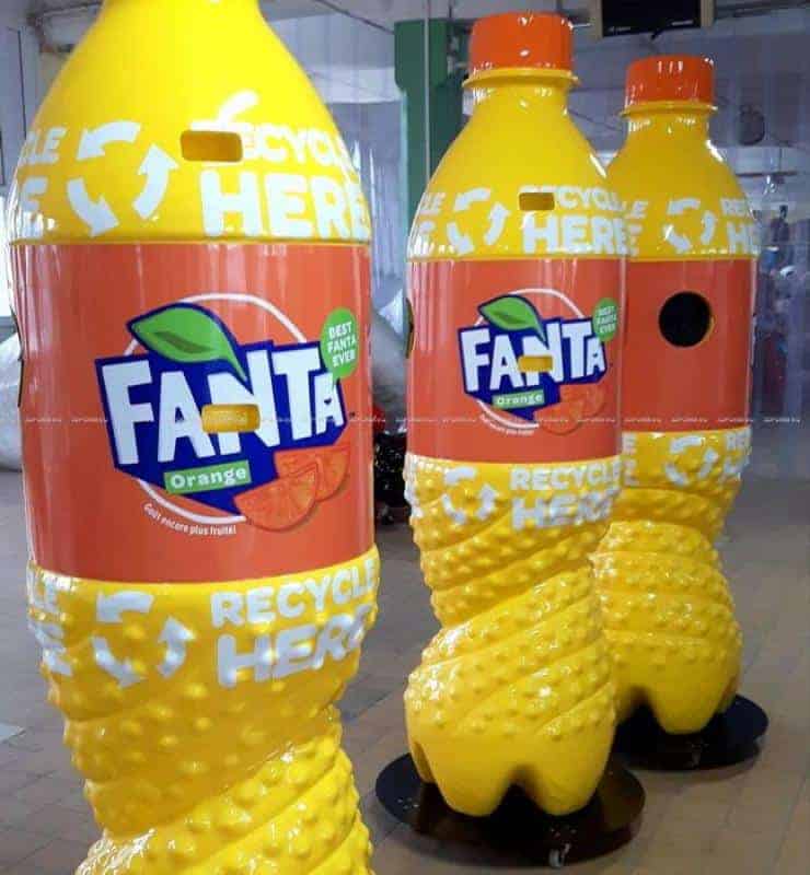 Werbeflaschen FANTA 4 Trzy duże pojemniki do recyklingu w kształcie butelek Fanta Orange.