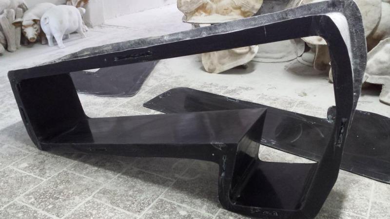 Czarno-brązowy stojak w warsztacie z figurami zwierząt na tle.