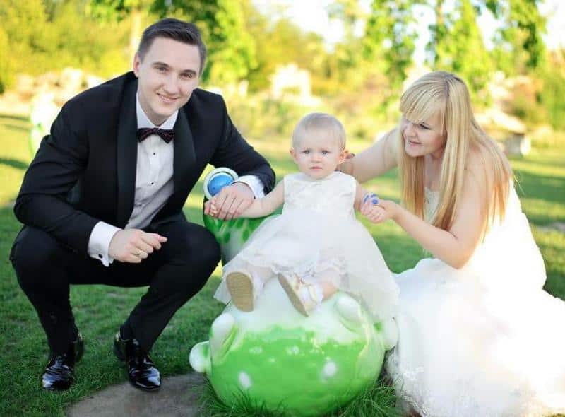 Figuren im Vergnügungspark 2 Mężczyzna w garniturze i kobieta w sukni ślubnej z małym dzieckiem na świeżym powietrzu.