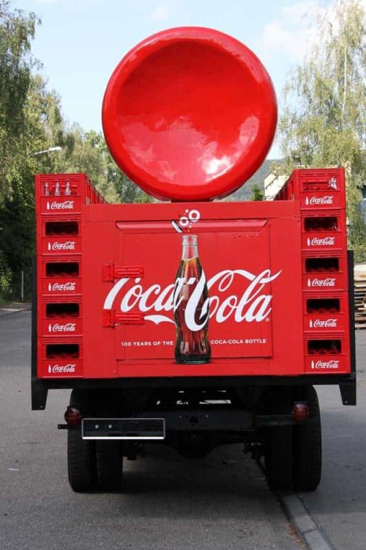 Werbetruck von Coca Cola 4 Tył czerwonej ciężarówki promującej Coca-Colę z dużą butelką i logo marki.
