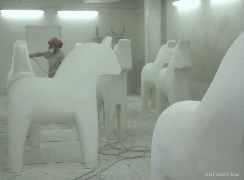 Künstlerisch bemalte Pferde aus Dalarna 3 Osoba malująca duże figury koni w warsztacie.