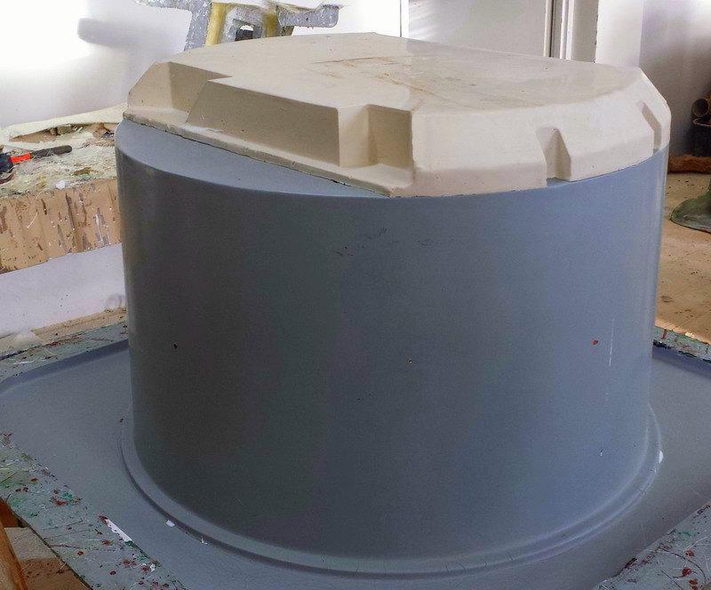 DANONE - werbliche Kühlgeräte 3 Szary pojemnik z białą pokrywą na stole warsztatowym.