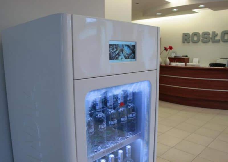 FINLANDIA Kühlvitrine 2 Lodówka z napojami w recepcji firmy. W tle biurko recepcyjne i neonowy napis na ścianie.