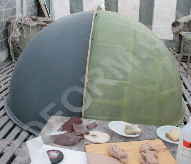 Große Kugel im Stadtbereich 3 Półokrągła konstrukcja w dwóch kolorach, otoczona narzędziami rzemieślniczymi na drewnianej podłodze.