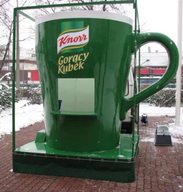 Mobile Werbung - Großer KNORR-Becher 1 Zielona gigantyczna filiżanka Knorr Gorący Kubek na zewnątrz, zimowa sceneria w tle.