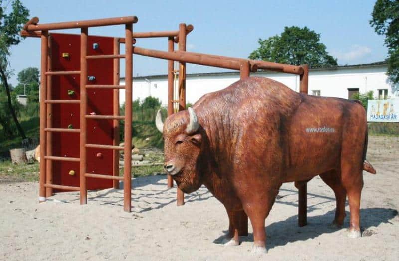 Figuren in einem Themenpark 6 Plac zabaw z dużą drewnianą konstrukcją i figurą żubra.