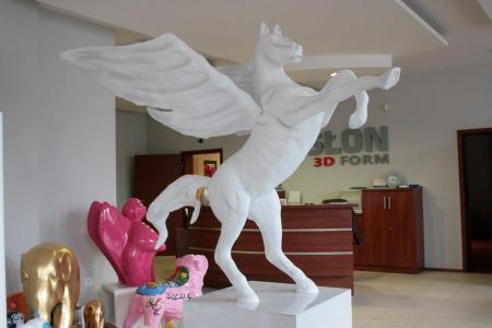 Logo in Form eines Pegasus 2 Biały posąg Pegaza w biurze z figurkami innych zwierząt.