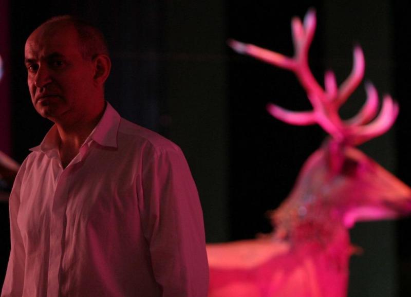 Bühnenbild-Elemente für das Dramatische Theater der Hauptstadt Warschau 2 Mężczyzna w białej koszuli stojący obok różowo podświetlonego jelenia.