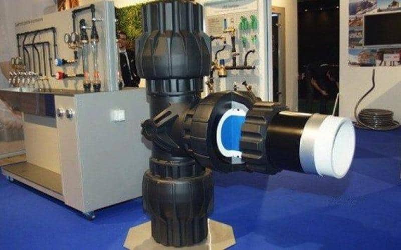 Wystawa z dużą armaturą wodociągową w pomieszczeniu targowym.