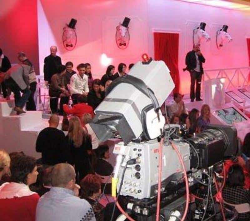 TVP2 - Bühnenelemente 3 Nagranie telewizyjne w studio z widownią i dużą kamerą na pierwszym planie. Dekoracje w czerwono-białej kolorystyce.