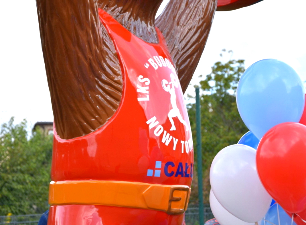 Großer Bär - Gewichtheben-Meisterschaften 1 Posąg niedźwiedzia w czerwonym stroju sportowym z białym napisem