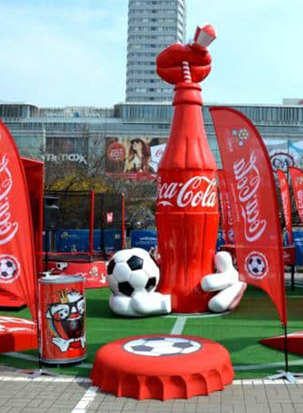 Coca-Cola-Flasche für die Euro 2012 2 Dekoracja plenerowa z dużą butelką Coca-Coli, piłką nożną oraz czerwonymi flagami.